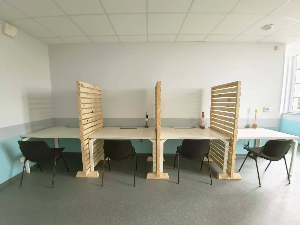 Bureaux en réemploi séparés par des claustras en bois clair issu de surcyclage.
