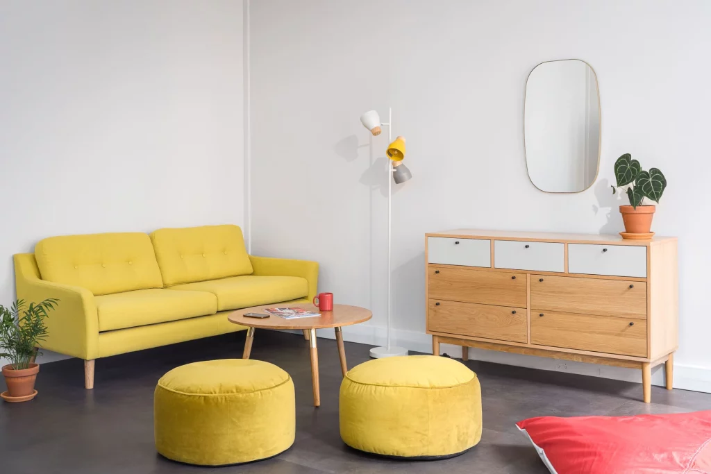 Un assemblement chaleureux de canapés et poufs jaune accordés à des meubles en bois clairs pour donner une touche de joie dans la vie de tous les jours.