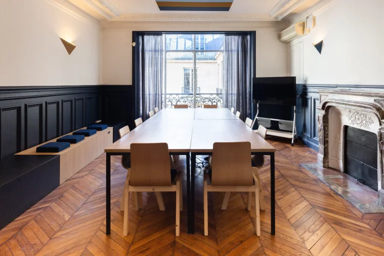 Grande pièce lumineuse avec en son centre une grande table en surcyclage pouvant accueillir 12 personnes.