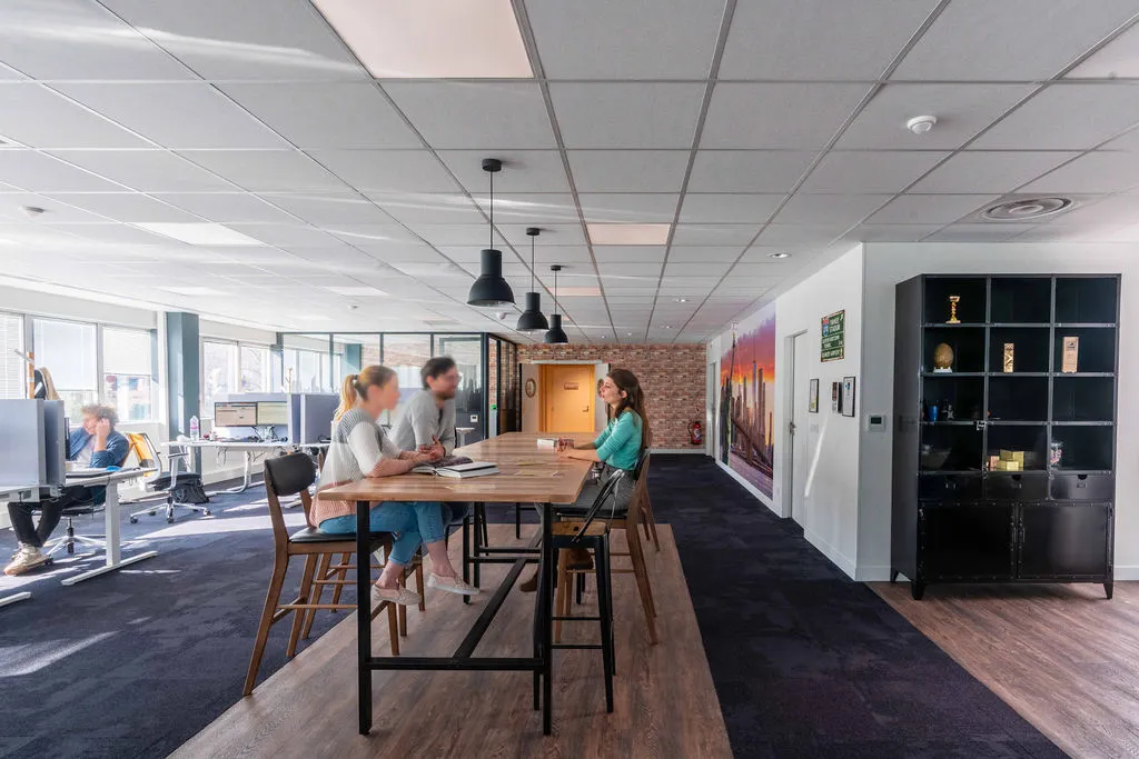 Vue sur un centre d'appel réaménagé avec du mobilier de réemploi au style chaleureux et à l'ambiance américaine.