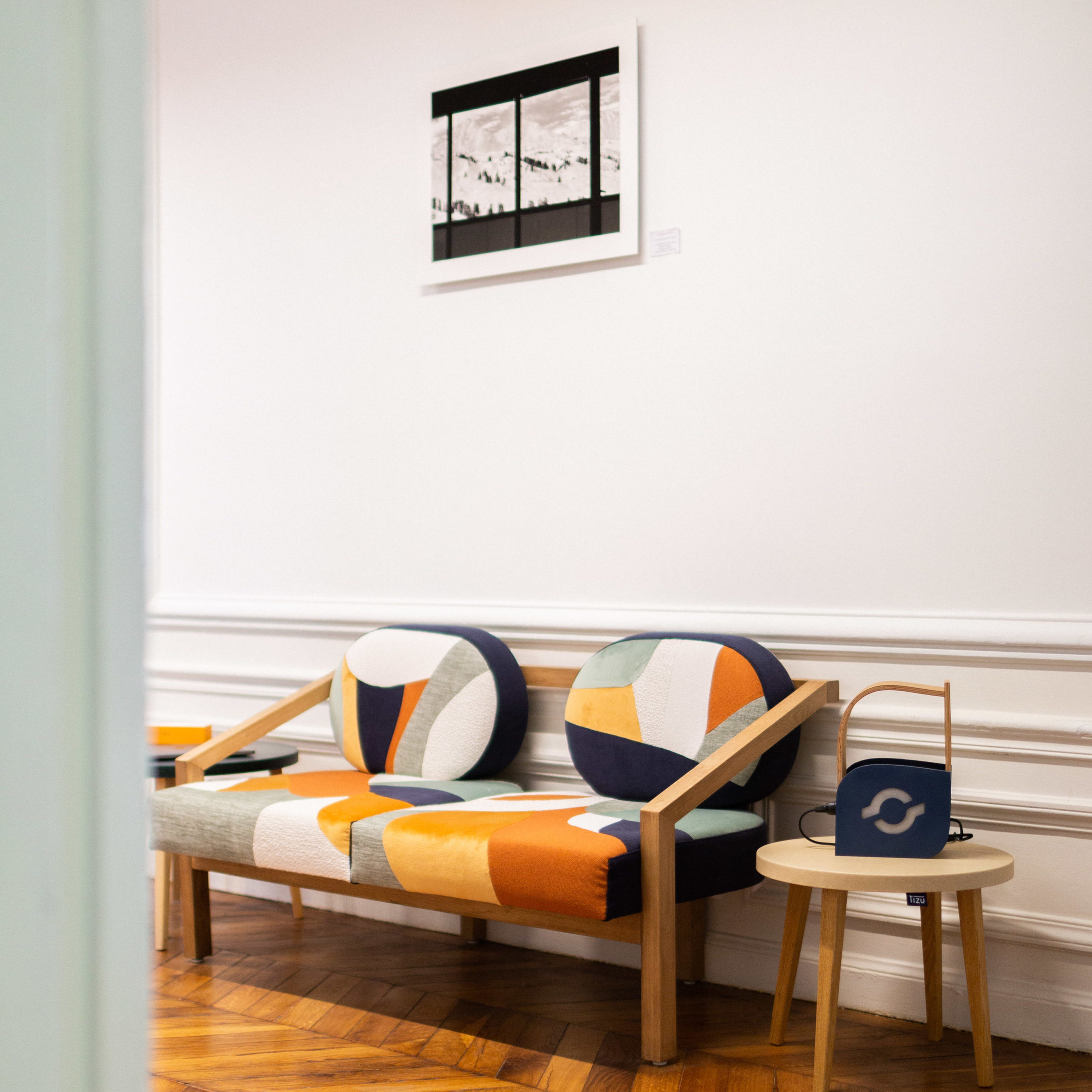 Vue de près sur un canapé de réemploi aux formes géométriques colorées : jaune, orange, vert, noir et blanc.